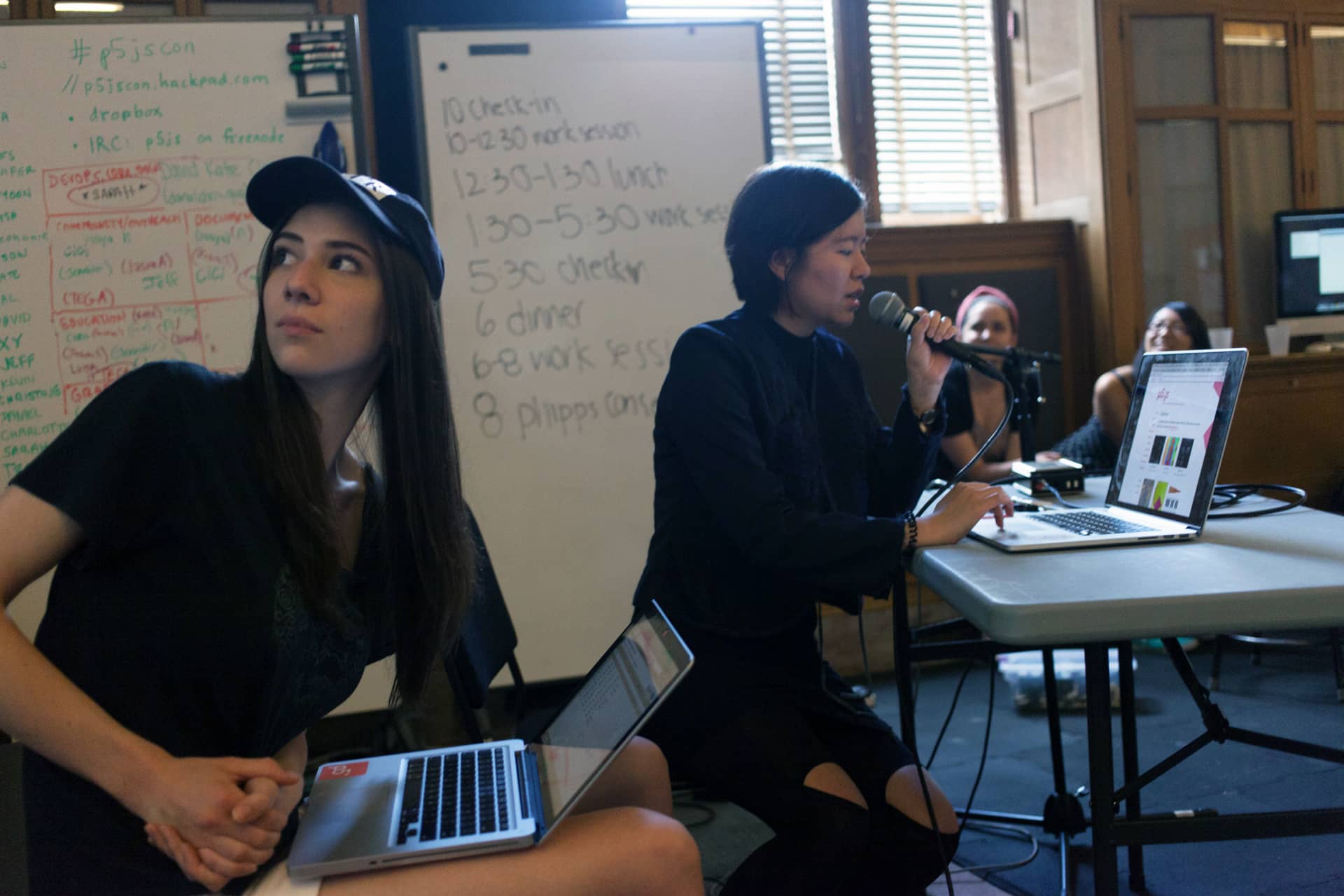 Woman reads about p5.js into a microphone to three female students"